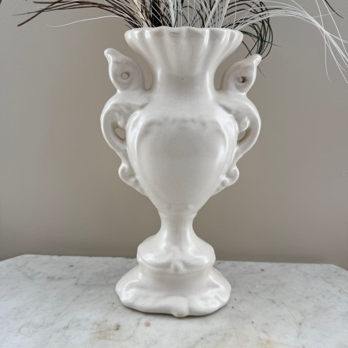 white vase with peacock feathers