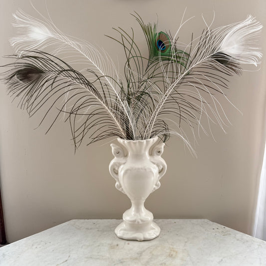 white vase with peacock feathers
